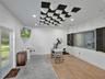 Ceiling-mounted acoustic soundproofing panels, recessed lighting, wood-finish flooring, glass-paneled interior window, and full-light exterior door