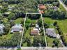 Expansive rectangular lot featuring established mature trees, sprawling green space, and a paved driveway