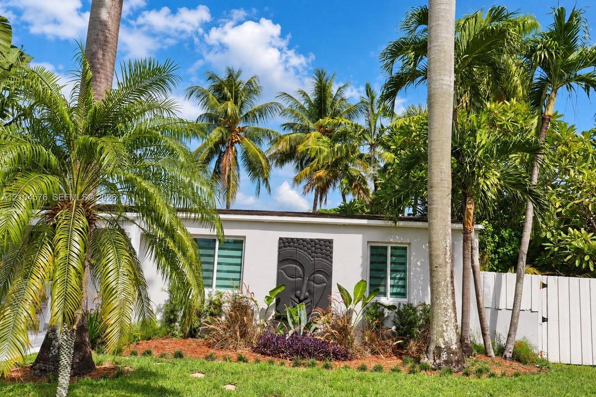 Exterior elevation featuring smooth stucco siding, low-profile soffit lighting, and custom relief wall art