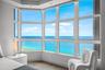 Expansive bay window featuring multi-pane glass panels, recessed ceiling lighting, and wood-finish flooring