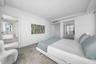 Neutral color palette featuring wood-finish flooring, recessed ceiling lighting, and mirrored closet doors