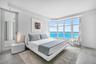 Bay window featuring ocean water, wood-finish flooring, and recessed ceiling lighting