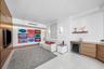 Wood-finish wall paneling, built-in cabinetry with integrated wine cooler, floating display shelf, and polished tile flooring