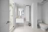 Modern bathroom featuring a glass-enclosed shower, wall-mounted floating vanity, integrated rectangular sink, full-height decorative tile backsplash, 