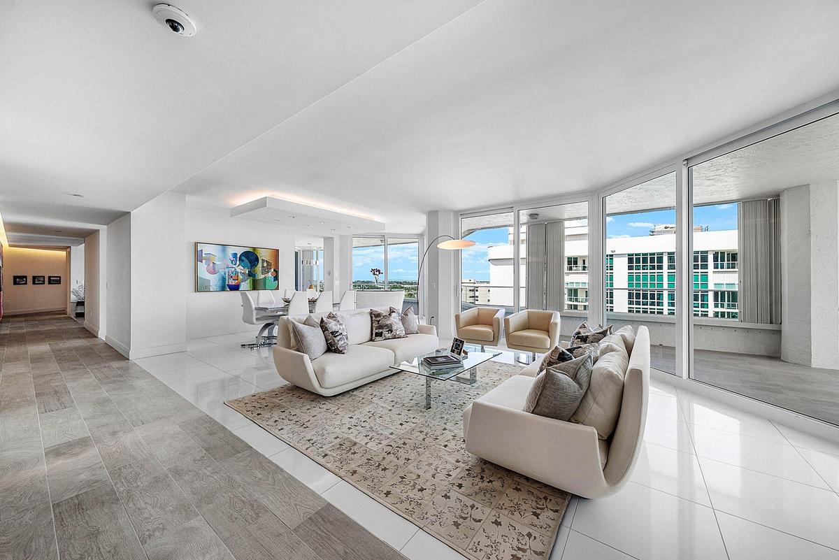 Open-concept interior featuring large-format tile flooring, floor-to-ceiling windows, and a recessed ceiling architectural detail with integrated ligh