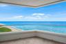 Covered balcony featuring wood-finish flooring and frameless glass railings
