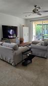 Large-format tile flooring, ceiling fan with integrated lighting, and full-height sliding glass door