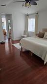 Wood-finish flooring, vaulted ceilings, and a ceiling fan with integrated lighting