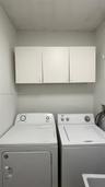Dedicated laundry area featuring white wall-mounted cabinetry