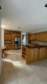 Kitchen featuring extensive wood cabinetry, dark stone countertops, tile flooring, recessed lighting, and built-in appliances