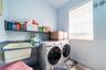 Laundry room featuring a wall-mounted utility sink, built-in shelving, and a horizontal window with attached blinds