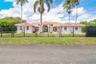 Single-story residence featuring a tile roof, arched entryway, and horizontal metal fencing