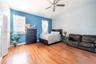 Wood-finish flooring, ceiling fan with integrated lighting, and louvered closet doors