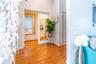 Interior space featuring wood-finish flooring, white-framed French doors with glass panes, and louvered closet doors