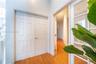 Six-panel closet doors, wood-finish flooring, and glass-paneled double doors featuring brass hardware