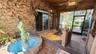 Screened-in porch featuring wood-shingle siding, a stone-accented fountain, wood-plank ceiling with skylight, and stone tile flooring