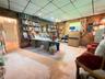 Wood-paneled walls, built-in floor-to-ceiling shelving, and adjustable track lighting