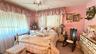 Bedroom featuring large windows with ceiling-mounted fabric valances, wall-to-wall carpeting, and a ceiling fan with integrated lighting