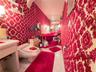 Raised platform area featuring a soaking tub, wall-mounted light fixtures, patterned wallpaper, and hexagonal tile flooring