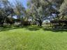 Expansive grounds featuring mature shade trees, a covered outdoor pavilion, and open green space