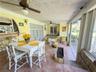 Covered patio featuring large-format terra-cotta tile flooring, dual ceiling fans, a built-in planter, and expansive glass sliding doors