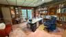 Wood-paneled walls, built-in wooden shelving, and glass-paned French doors