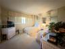 Neutral-toned bedroom featuring carpeting, ceiling-mounted light fixtures, full-height wall mirrors, and large-format horizontal windows