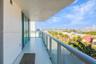 Covered balcony featuring large-format tile flooring, a glass-panel railing, and floor-to-ceiling glass sliding doors