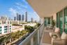 Covered outdoor balcony with a glass panel railing and panoramic city skyline backdrop