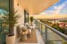 Covered balcony featuring tile flooring, full-height glass sliding doors, and a metal railing with a glass panel insert