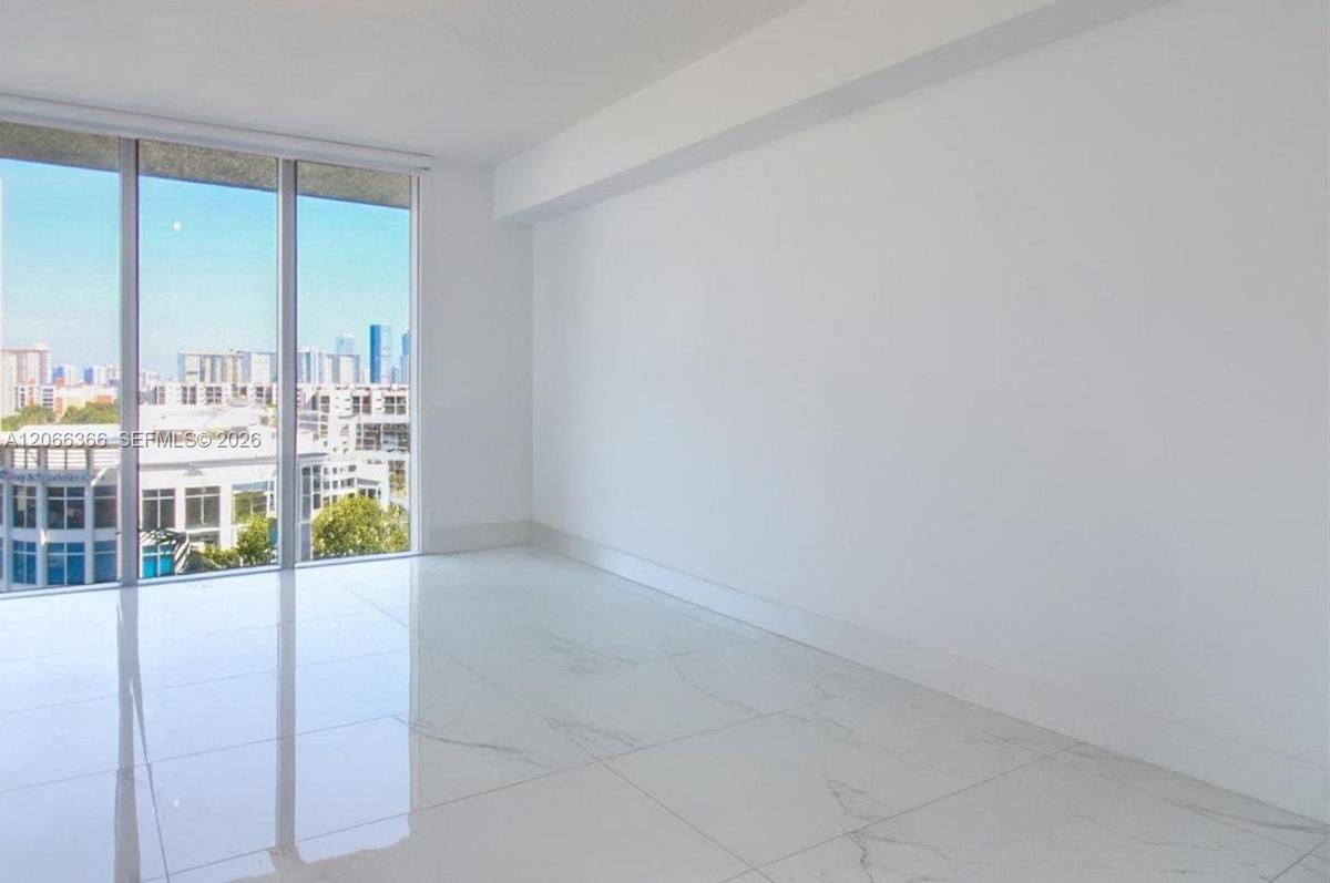 Floor-to-ceiling windows, large-format polished tile flooring, and urban skyline backdrop