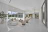 Expansive open-concept room featuring high ceilings with recessed lighting, large-format polished tile flooring, and floor-to-ceiling glass sliding do