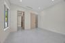 Neutral-toned room featuring smooth concrete-finish flooring, recessed lighting, light-wood interior doors, and a sliding barn-style door