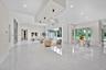 Open-concept living space featuring high-gloss tile flooring, recessed lighting, a tiered tray ceiling with cylindrical pendant fixtures, and floor-to