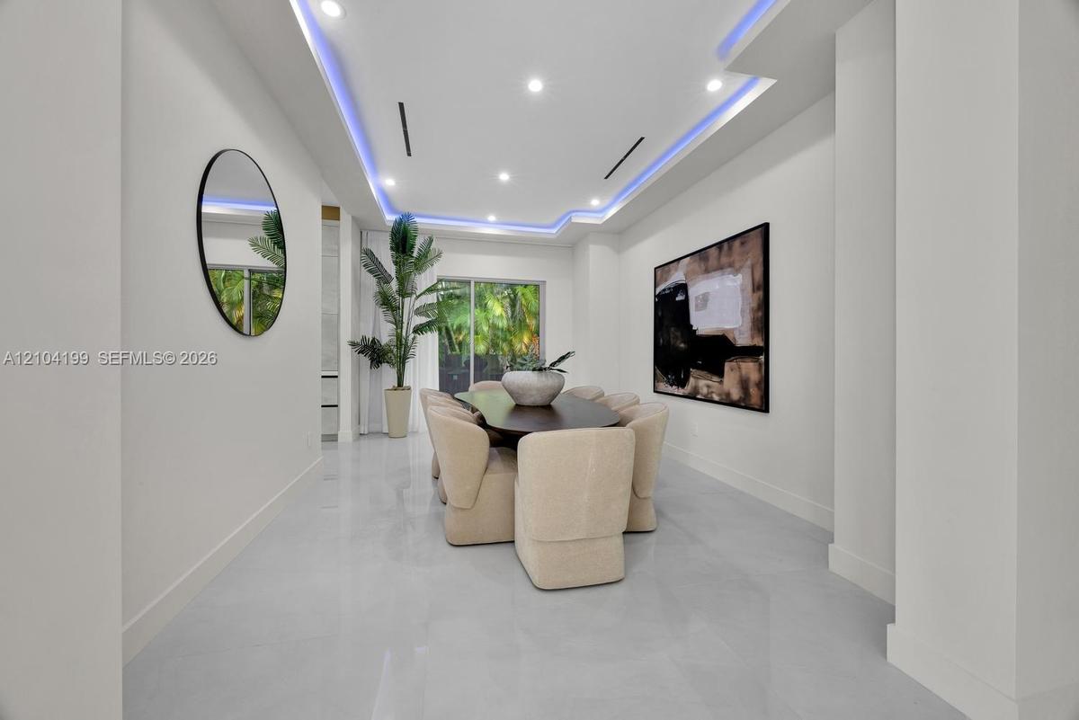 Tray ceiling featuring recessed accent lighting, large-format tile flooring, and sliding glass doors