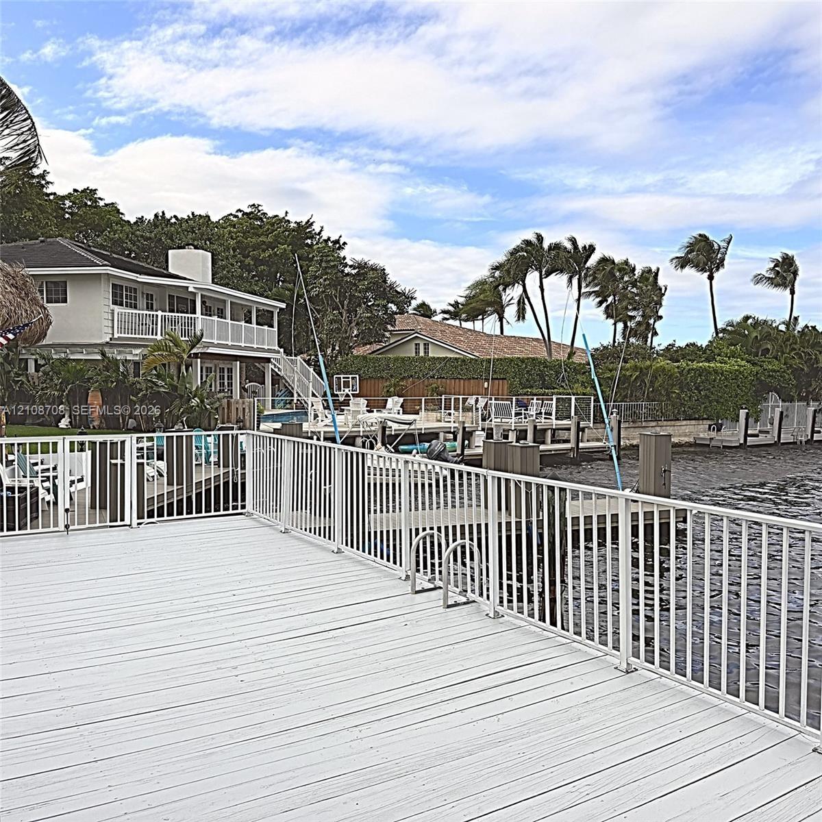 Waterfront wood-finish deck with whitenmetal safety railings and integrated dock ladder