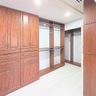 Custom wood-finish cabinetry featuring integrated drawers, shelving, hanging rods, and built-in metal hardware