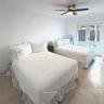 Large-format tile flooring, multi-pane glass french doors, and a ceiling-mounted light fixture with a five-blade fan