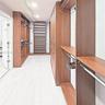 Custom walk-in closet featuring extensive wood-finish cabinetry, built-in shelving, integrated hanging rods, recessed ceiling lighting, and light-tone