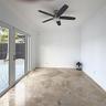 Polished stone flooring, crown molding, multi-panel glass French doors, and a brushed-nickel ceiling fan with integrated lighting