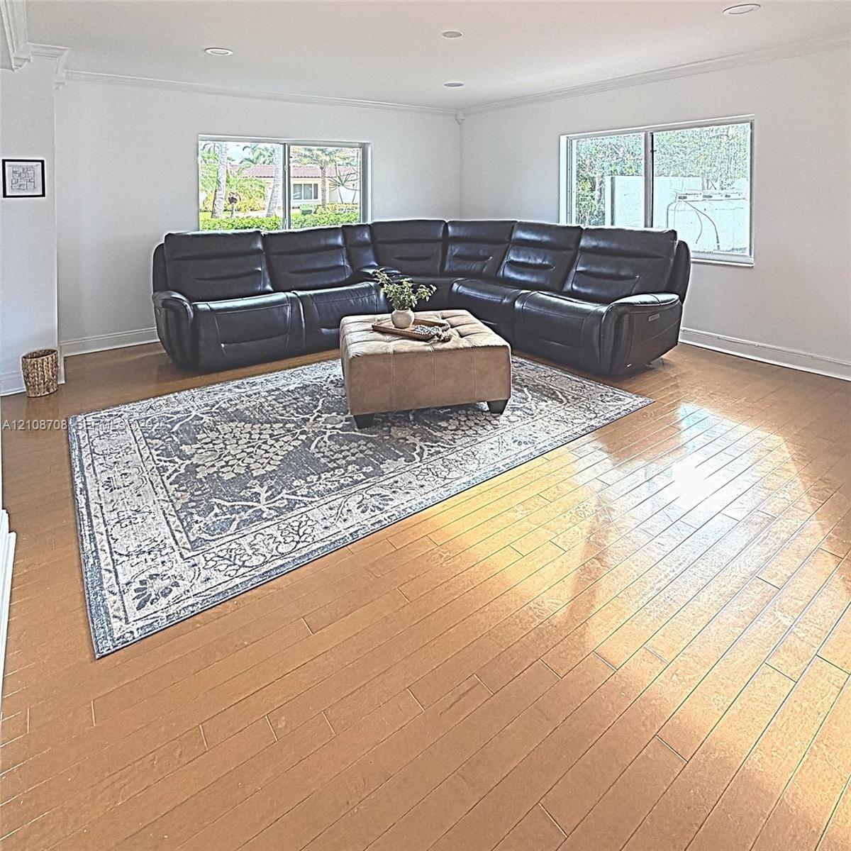 Spacious interior featuring wood-finish flooring, recessed lighting, and multiple large windows