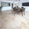 Open-concept floor plan featuring large-format stone flooring, a pass-through service counter, and a ceiling-mounted fan