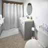 Bathroom featuring a vanity with a rectangular sink, oval wall-mounted mirror, ceramic tile flooring, and a tub-shower combination with a curtain rod