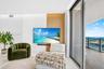 Custom accent wall featuring vertical wood-slat and fluted detailing, recessed ceiling lighting, and expansive floor-to-ceiling sliding glass doors le