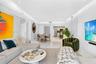 Open-concept living space featuring high-gloss large-format tile flooring, recessed ceiling lighting, and a floor-to-ceiling vertical slat accent wall