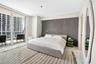 Floor-to-ceiling glass sliding doors, polished tile flooring, and a textured charcoal accent wall featuring recessed integrated lighting