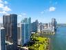 High-rise coastal cityscape featuring waterfront access, expansive green space, and architectural tower structures