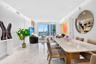 Open-concept living space featuring large-format polished stone flooring, recessed ceiling lighting, and floor-to-ceiling glass windows
