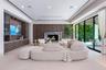Living area featuring custom wood-finish built-in cabinetry, stone-surround fireplace, dark wood paneled accent wall, recessed ceiling lighting, and f