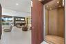 Private elevator with wood-panel interior finishes, large-format tile flooring, recessed ceiling lighting, and floor-to-ceiling glass sliding doors